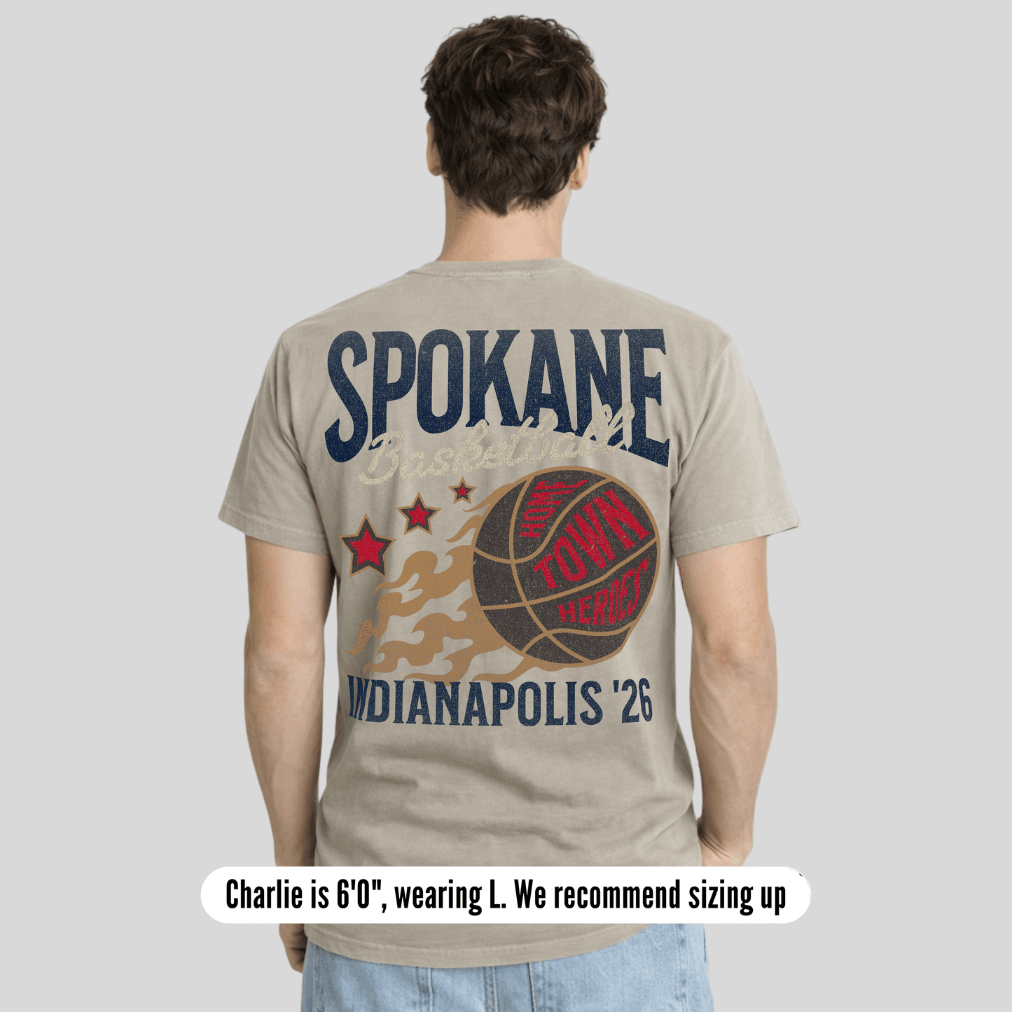 Person wearing a t-shirt with 'Spokane' and 'Indianapolis '26' text on the back, on a plain background.