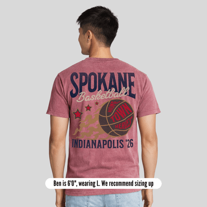 Person wearing a red t-shirt with 'Spokane Basketball' text and graphics on the back, standing against a plain background.
