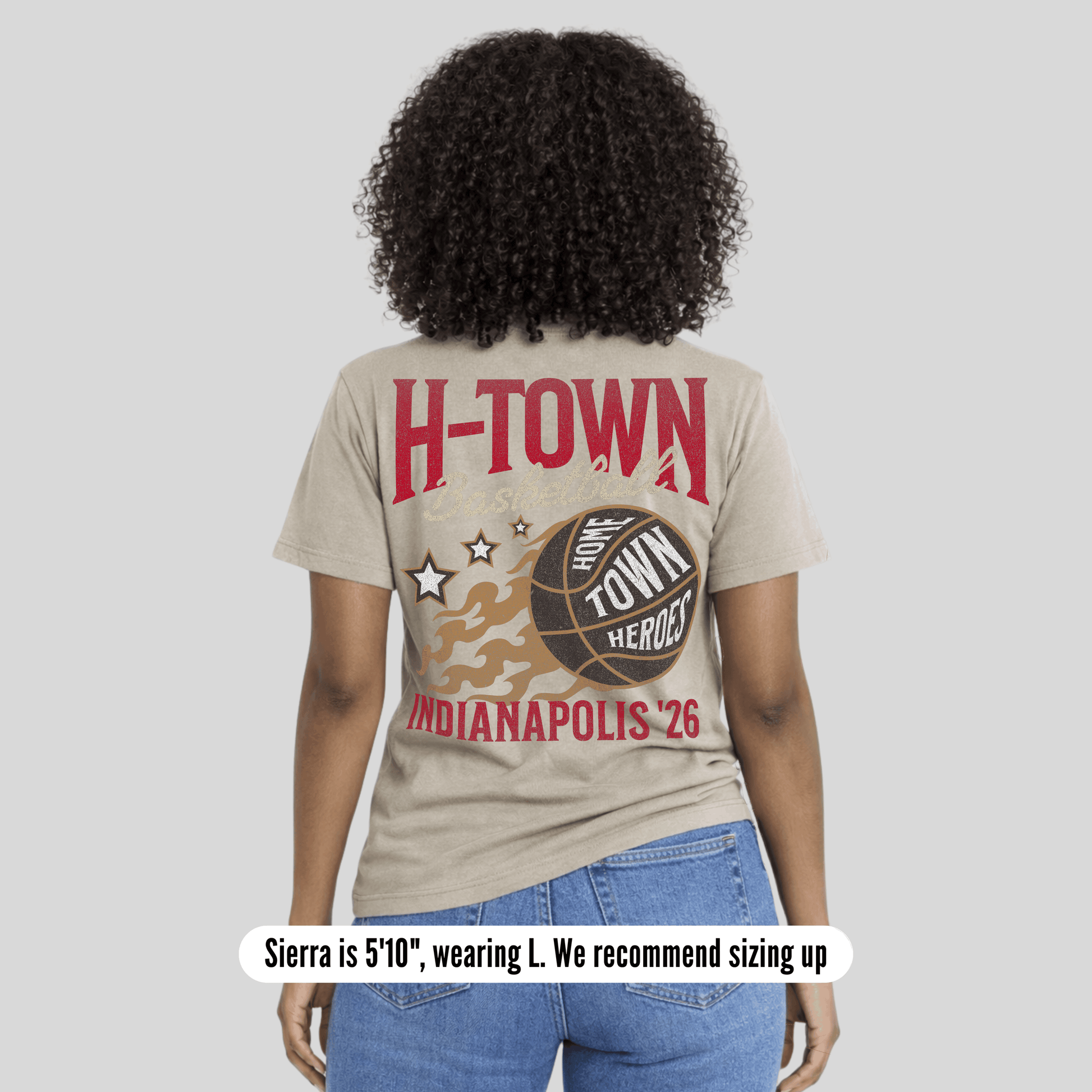 Person wearing a beige t-shirt with 'H-TOWN' and basketball design on the back, standing against a plain background.