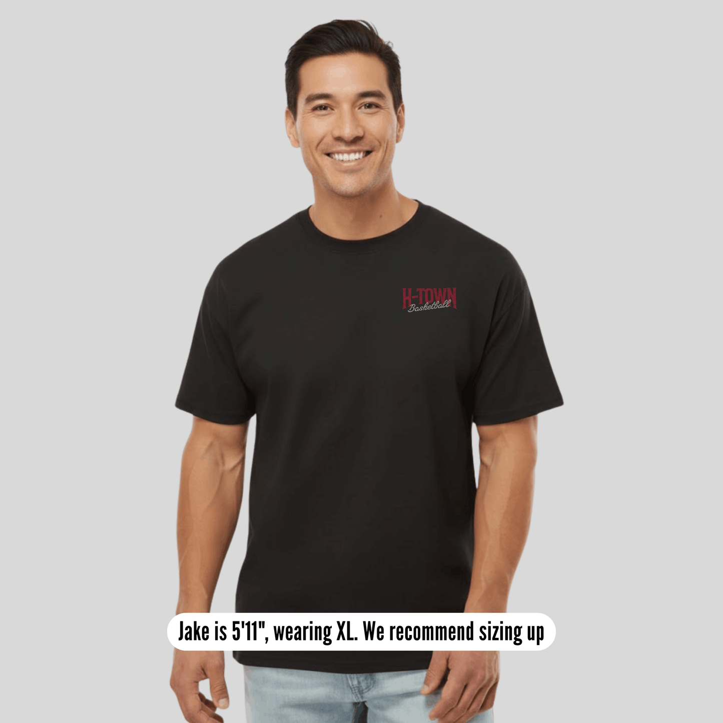 Man wearing a black t-shirt with a logo on a gray background