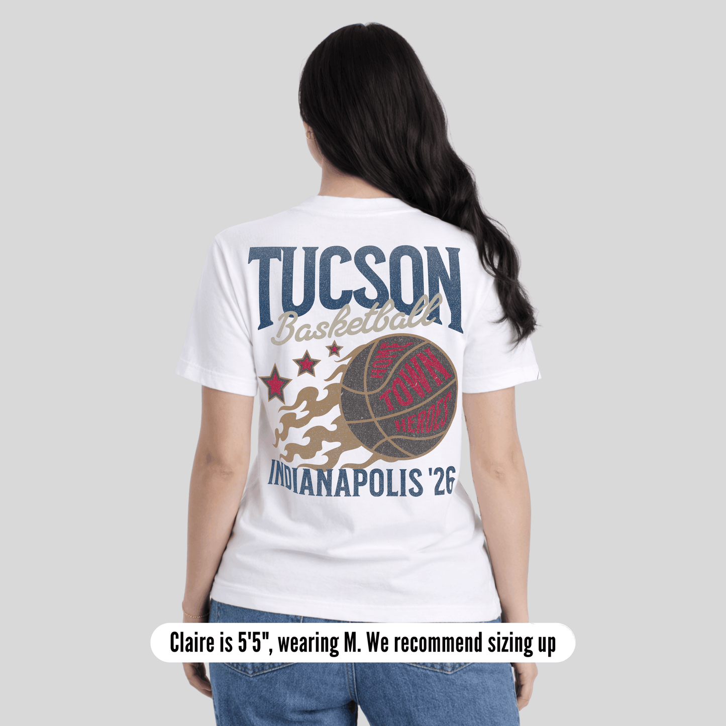 Person wearing a white t-shirt with 'Tucson Basketball' and 'Indianapolis '26' design on a plain background