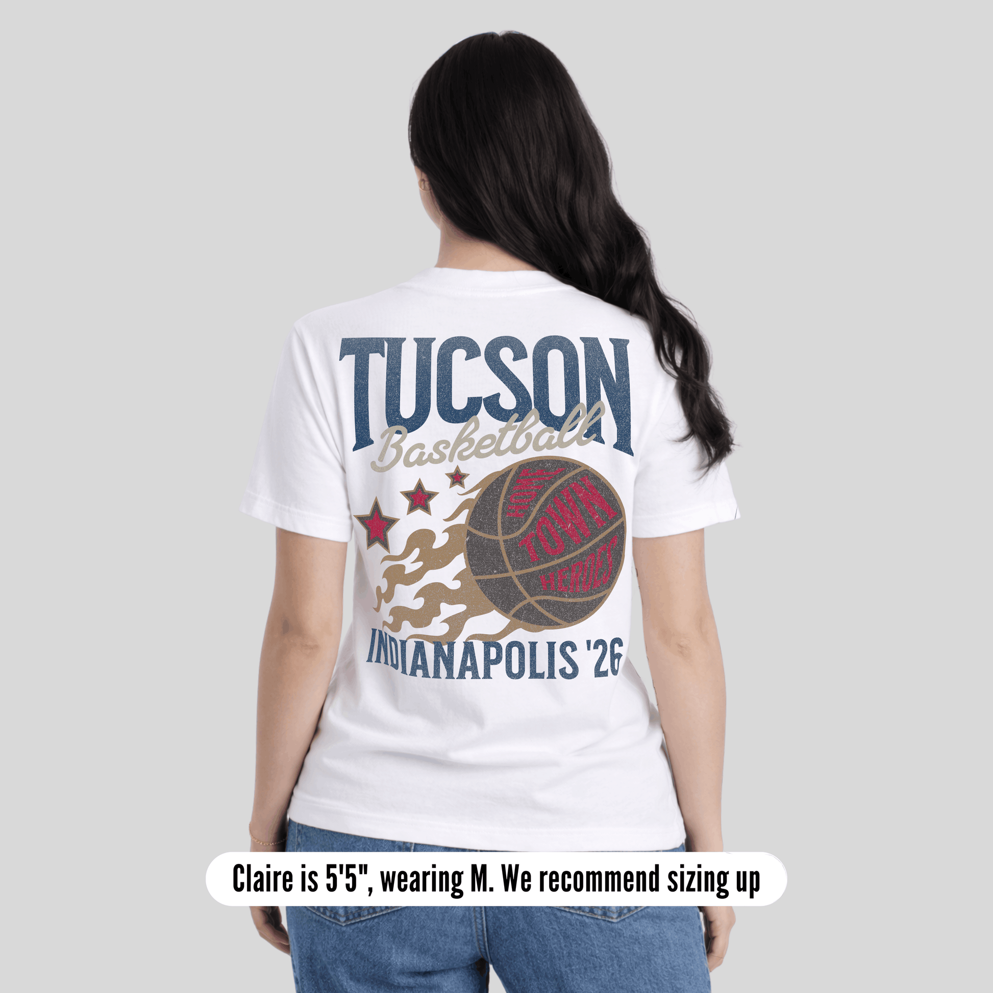 Person wearing a white t-shirt with 'Tucson Basketball' and 'Indianapolis '26' design on a plain background