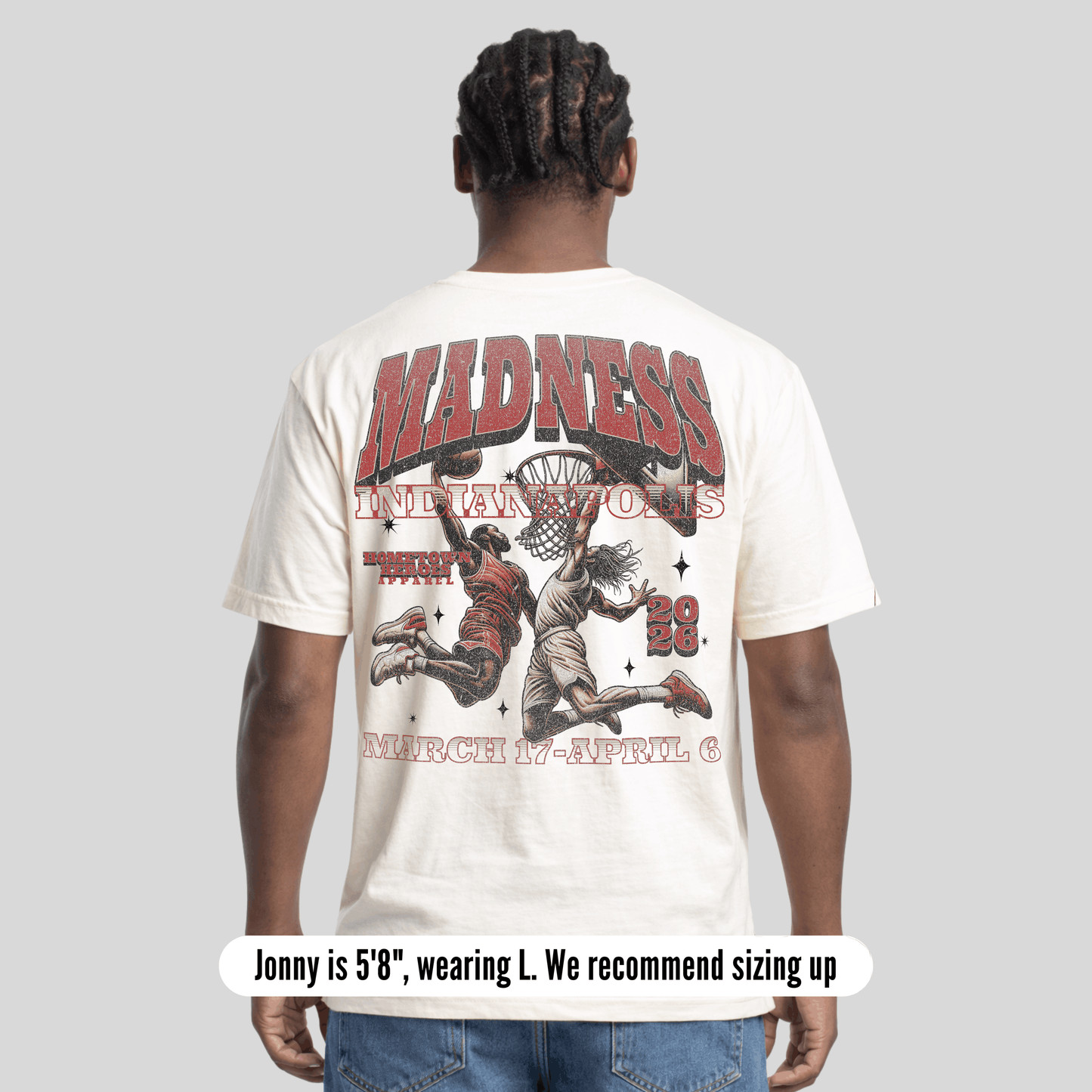Person wearing a white t-shirt with graphic design and text on the back, on a light gray background.