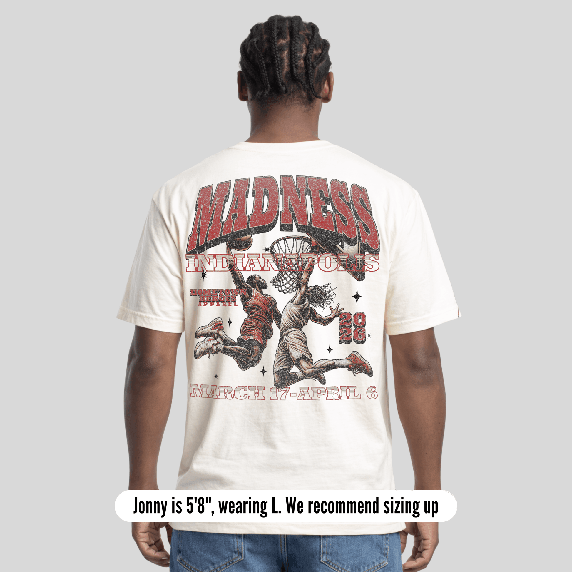 Person wearing a white t-shirt with graphic design and text on the back, on a light gray background.