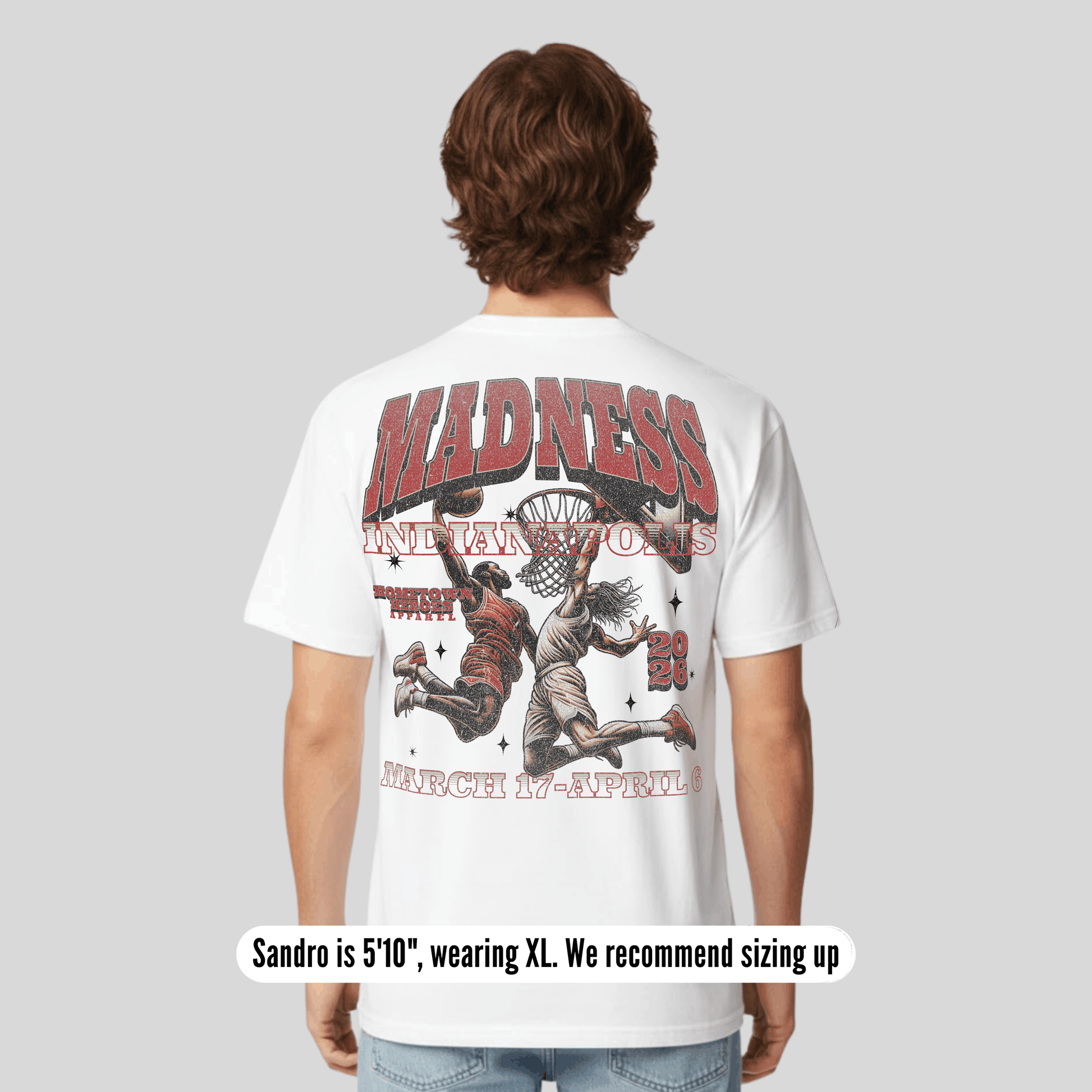 Person wearing a white t-shirt with graphic design and text on the back, on a plain background.