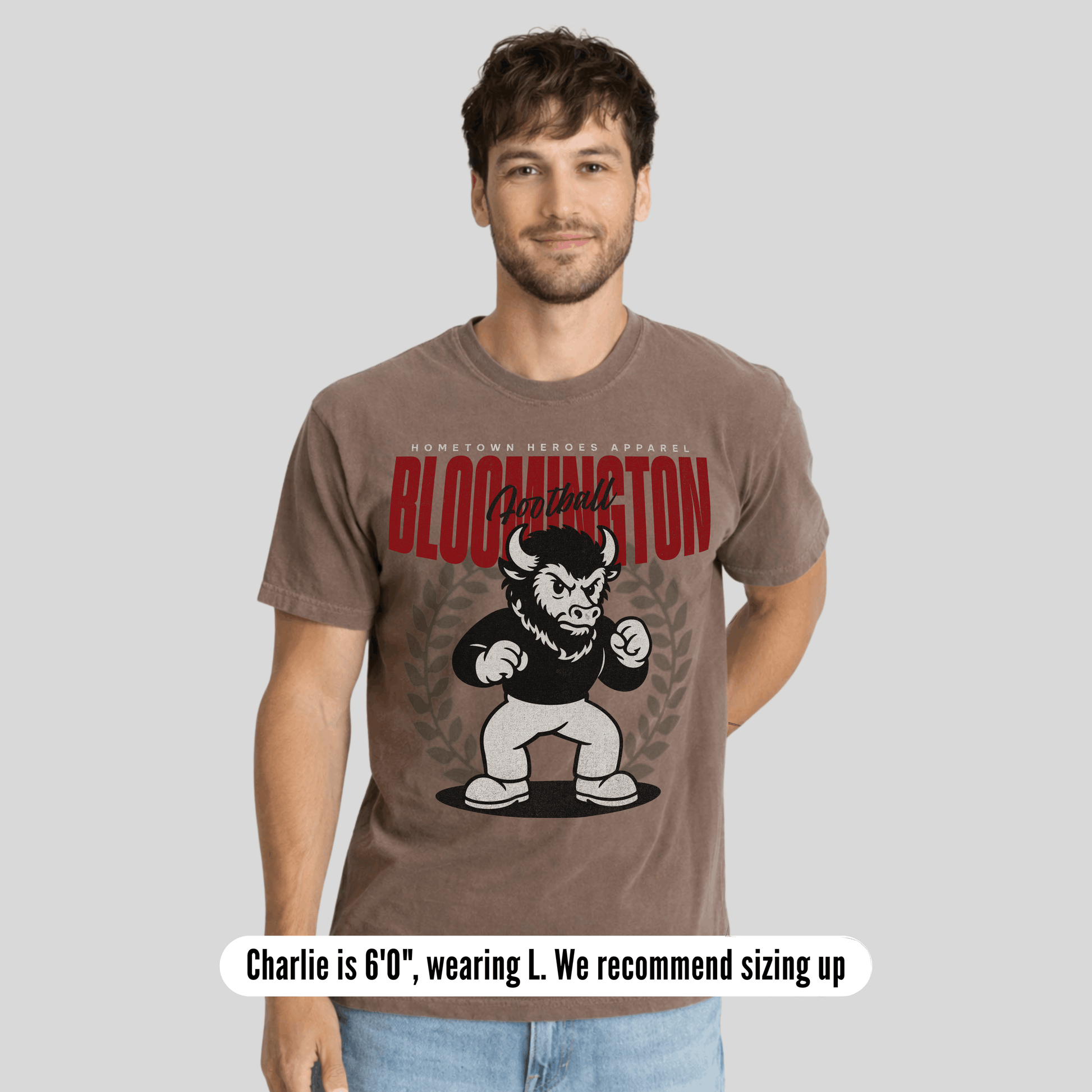 Man wearing a brown t-shirt with a graphic design on a gray background