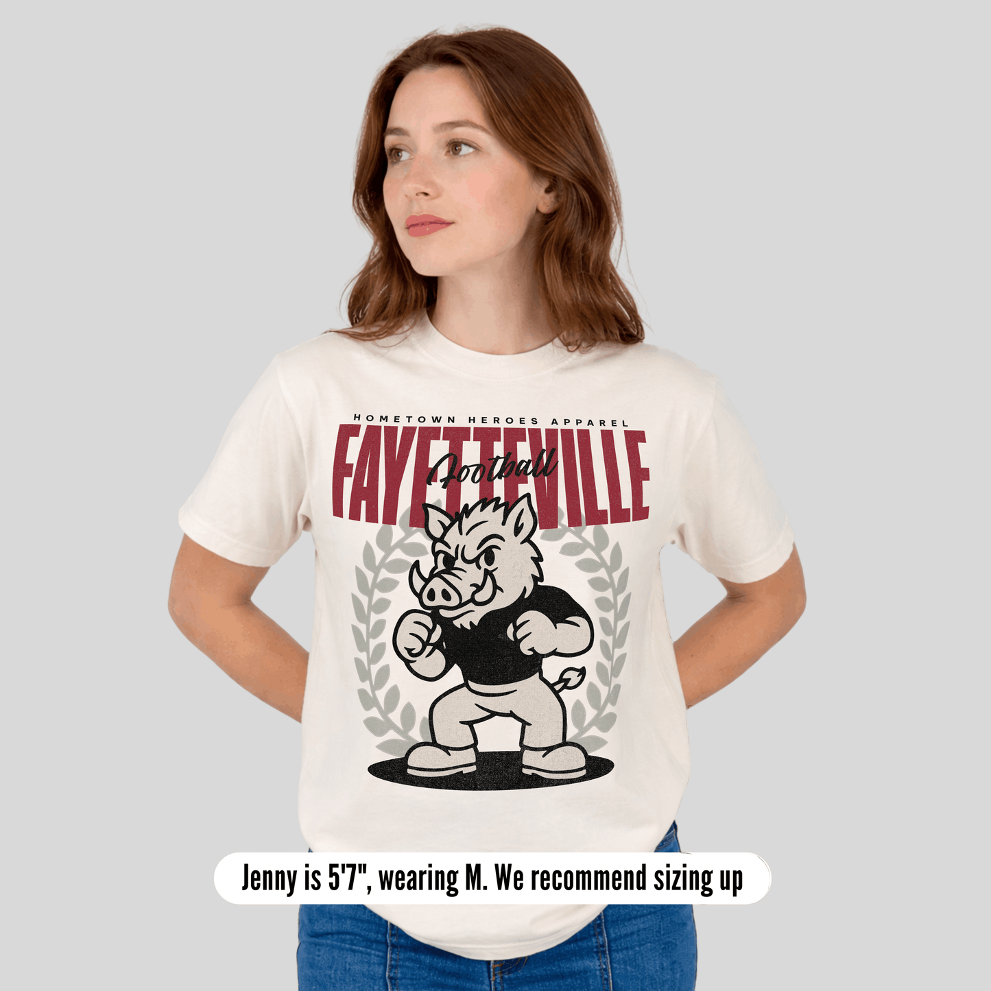 Woman wearing a white t-shirt with 'Fayetteville' and a mascot graphic on a gray background