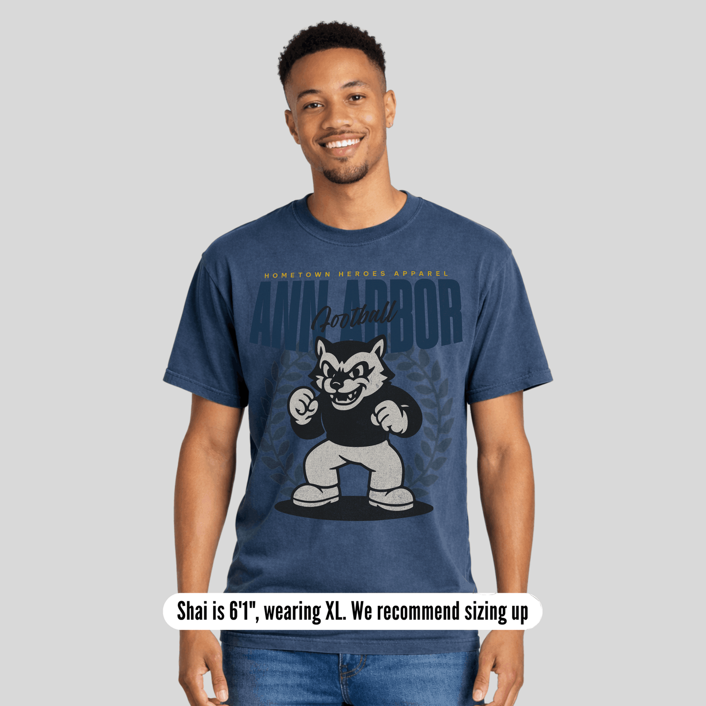 Person wearing a blue t-shirt with a graphic design on a gray background