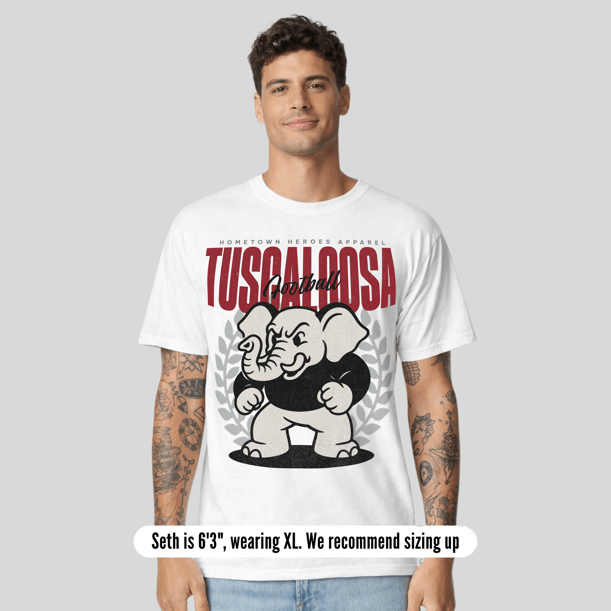 Man wearing a white t-shirt with 'Tuscaloosa' and an elephant graphic on a gray background