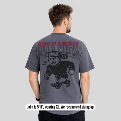 Man wearing a gray t-shirt with a graphic design on the back, standing against a plain background.