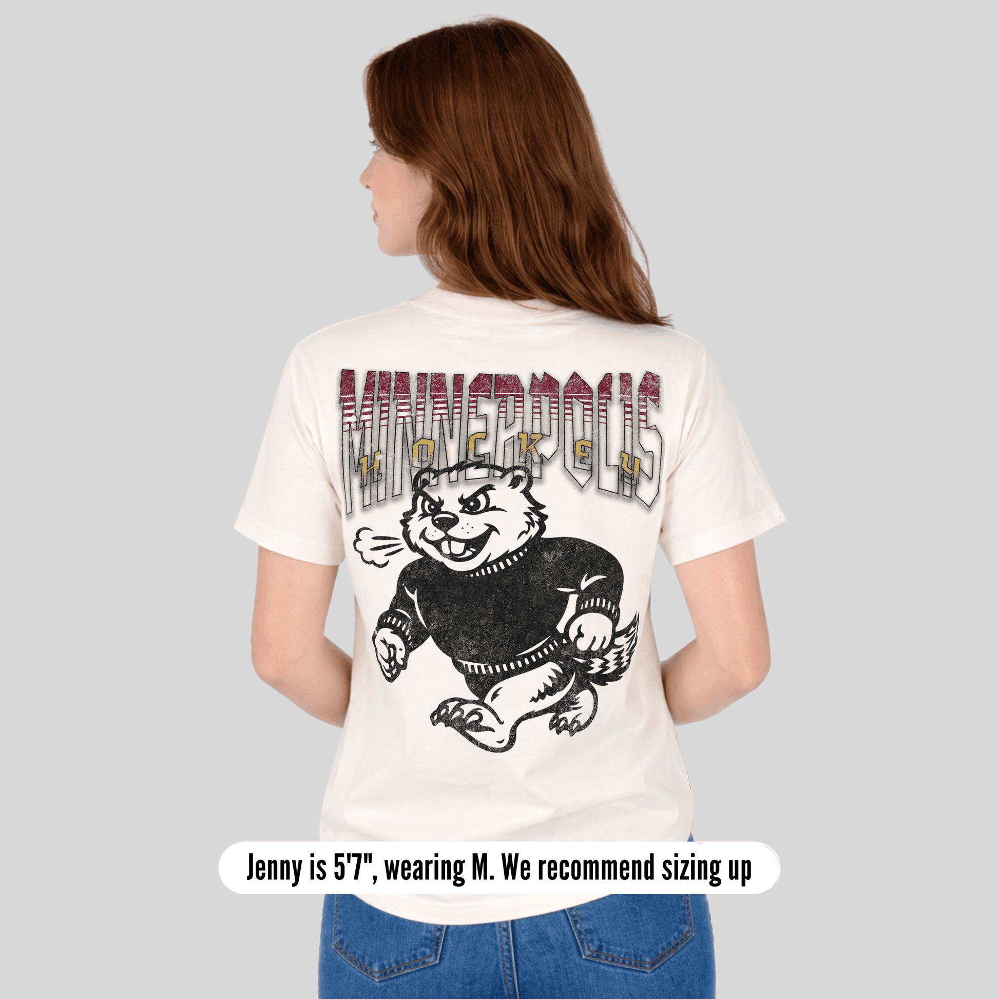 Person wearing a white t-shirt with a graphic design on the back, standing against a plain background.